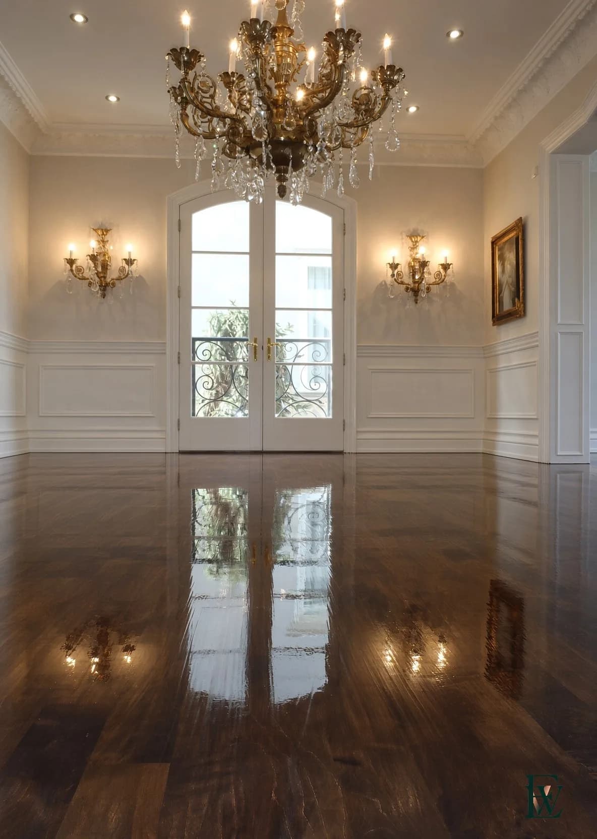 Dark oak salon floor running to French doors under a chandelier, frame 1 of 3, standing-height room view, Ecowoods site work, Toronto.