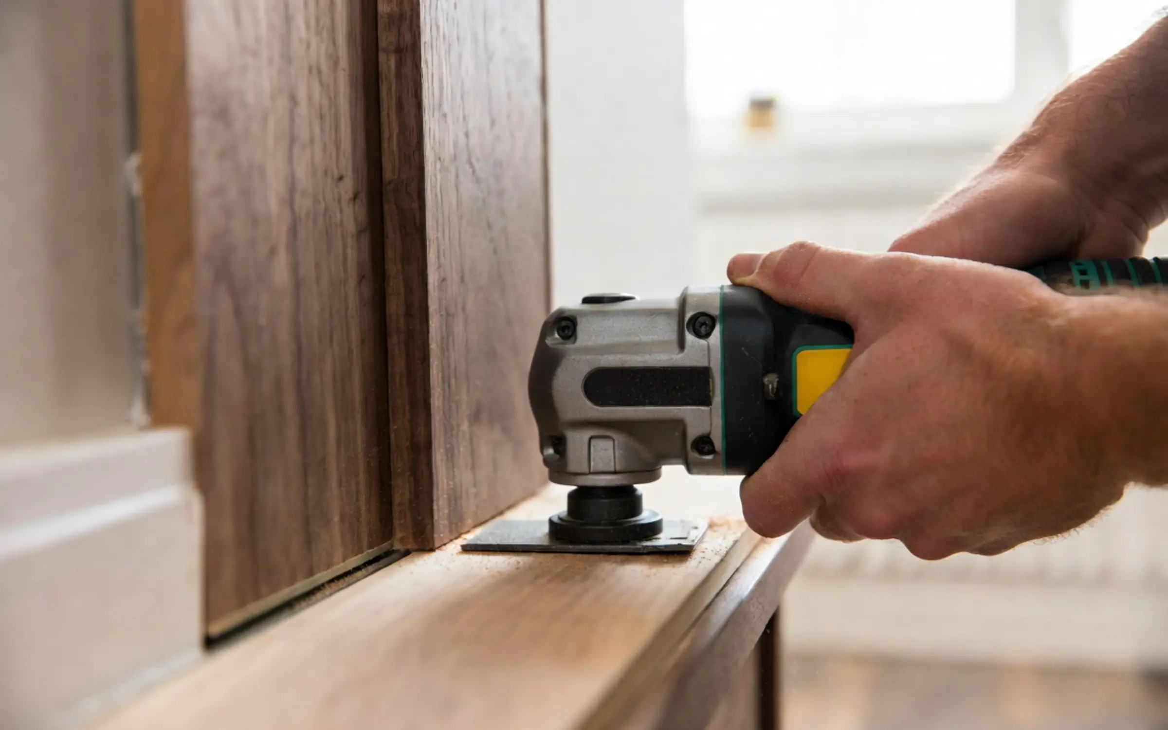 Jamb saw undercutting a door casing for hardwood flooring